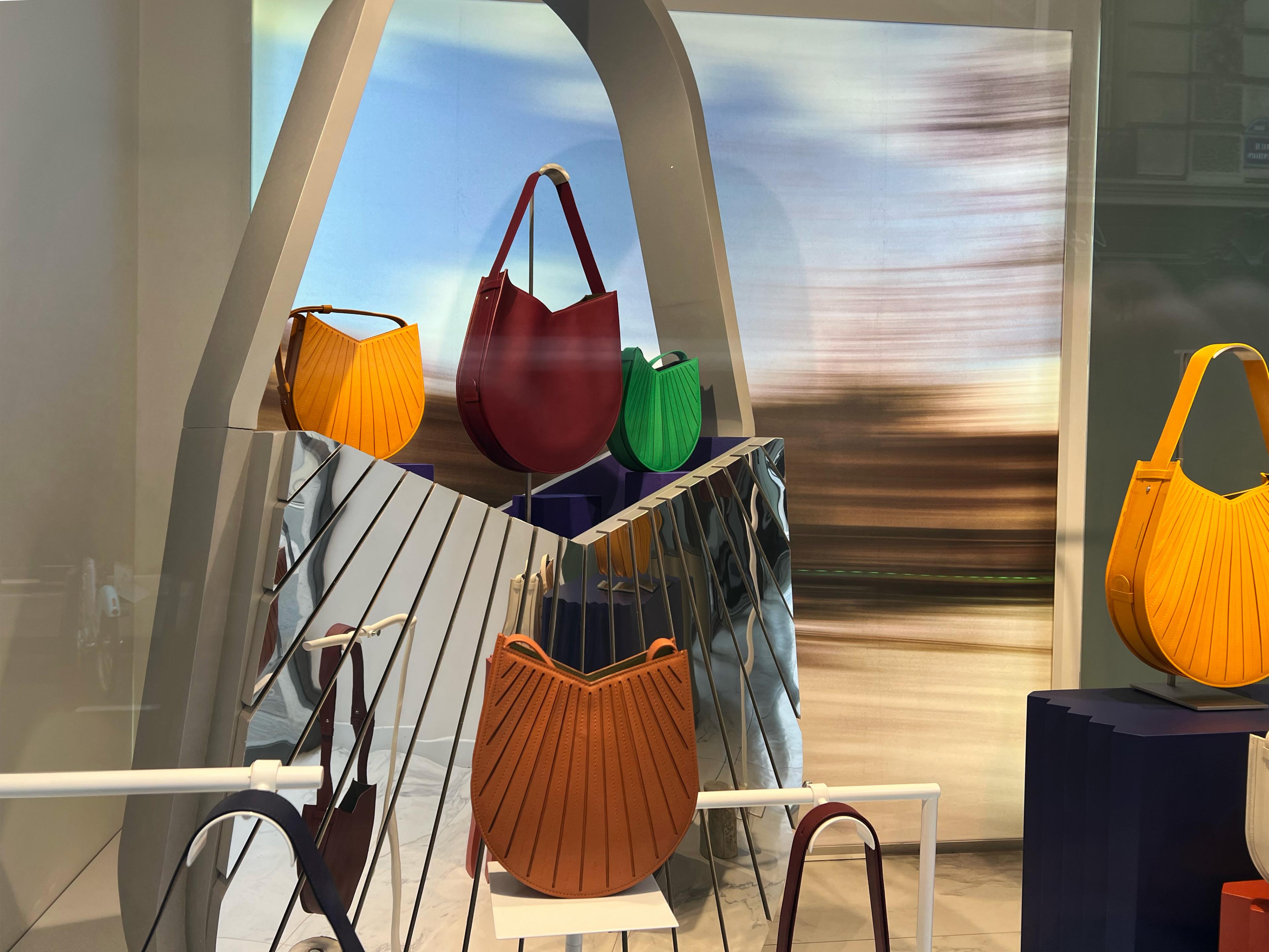 designer handbags on a contemporary display shaped like a metal handbag