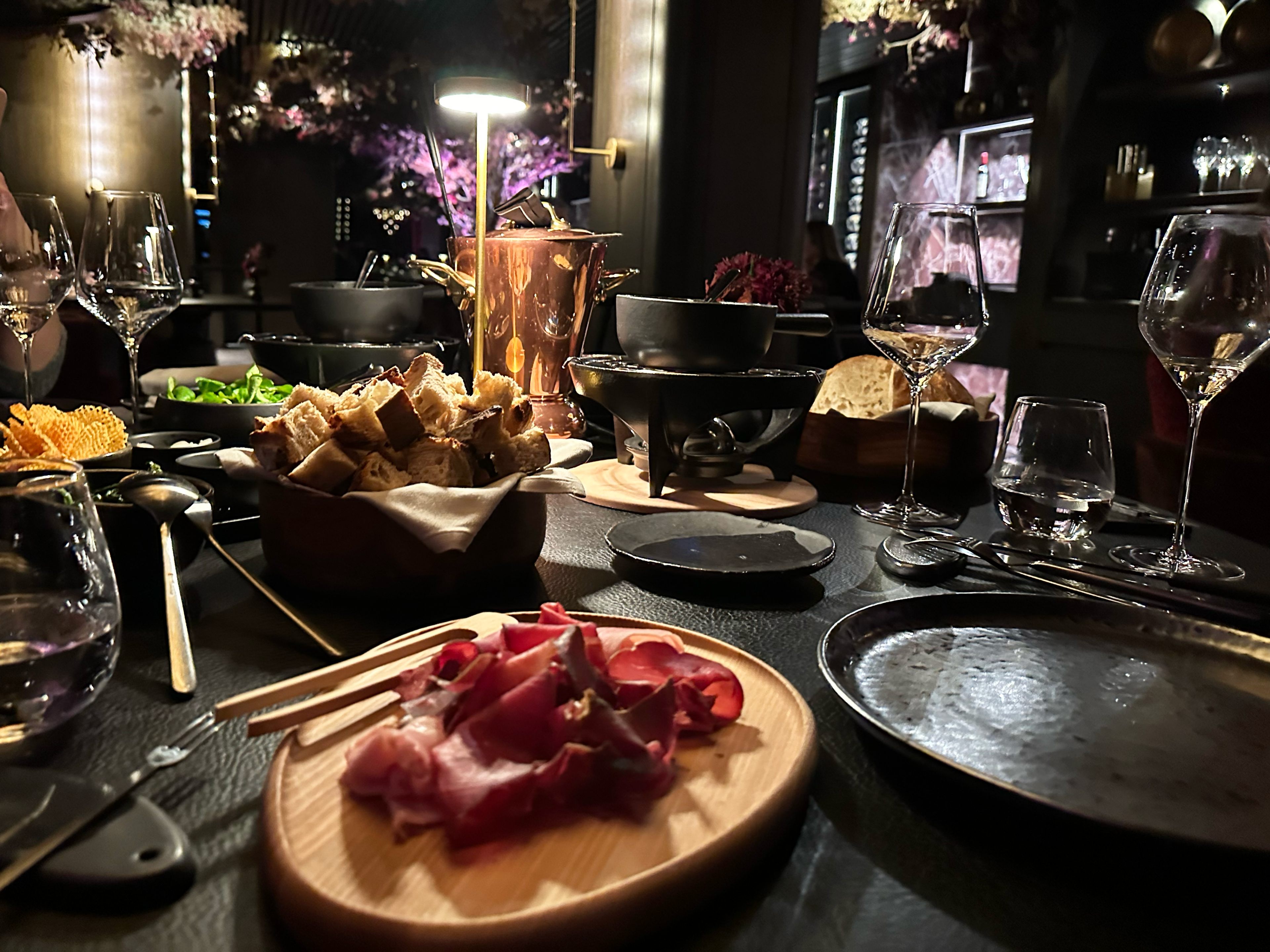 fondue and bread and wine in a dark restaurant