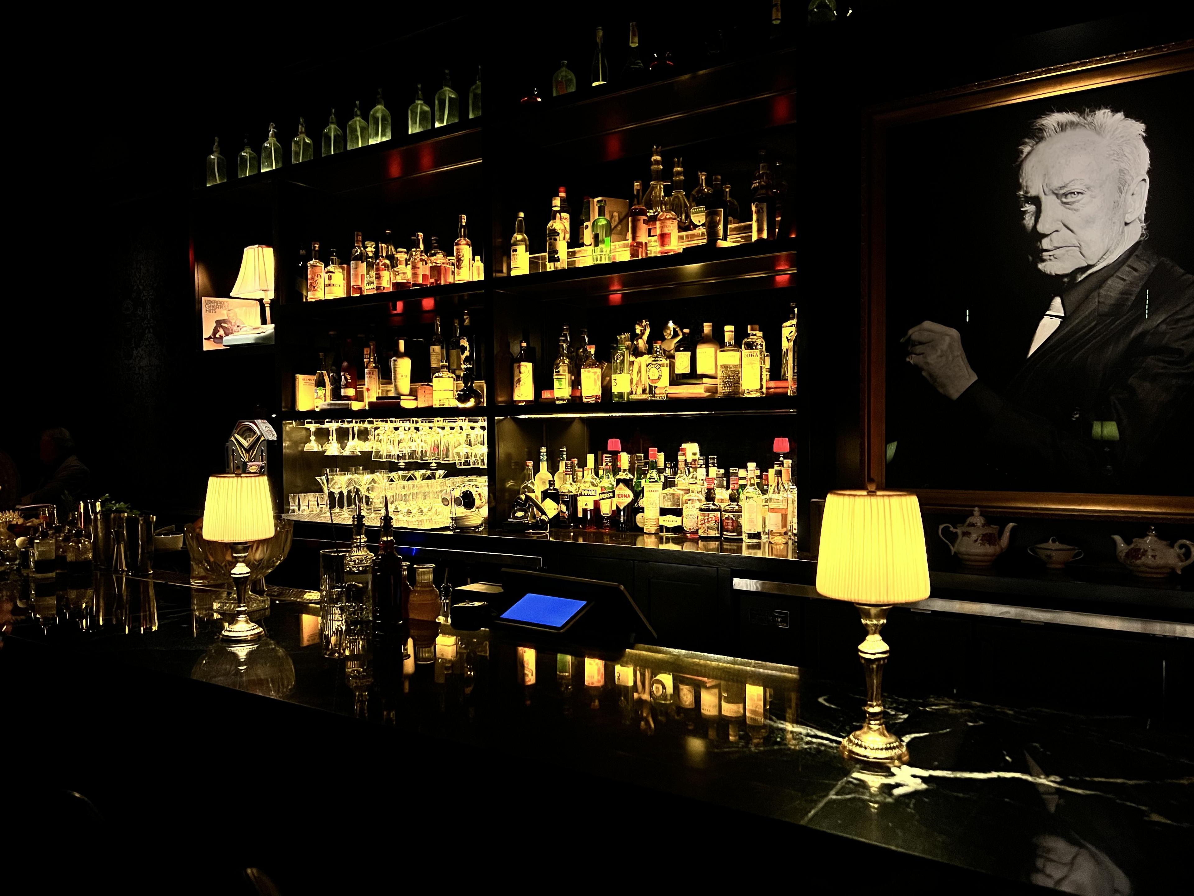 dark bar with liquor bottles lining the walls