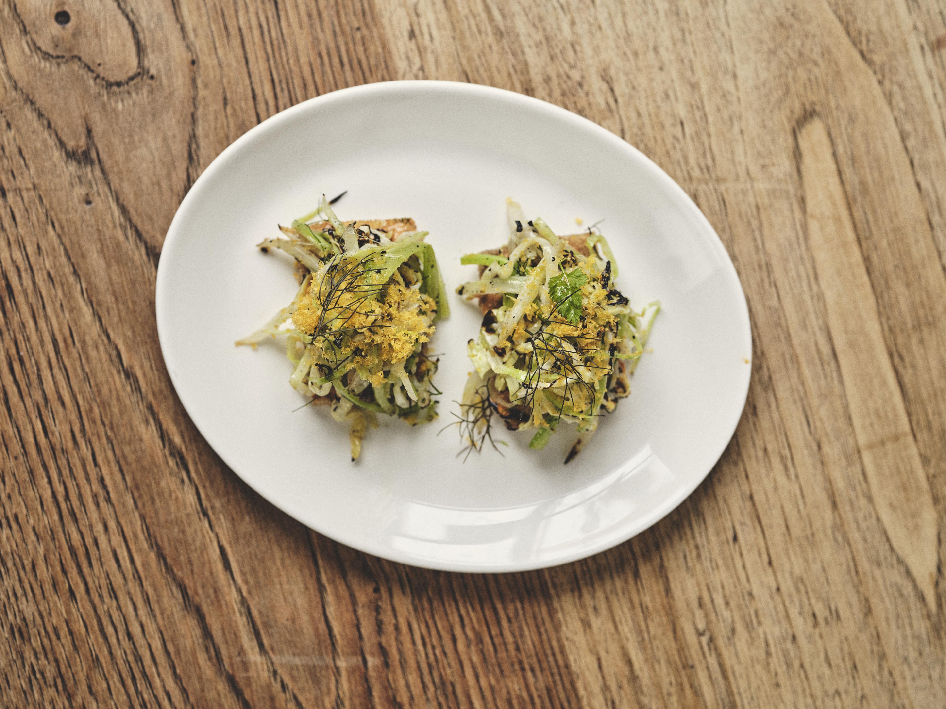Spider Crab On Toast, Grilled Celery, Fennel and Cabbage on a white plate