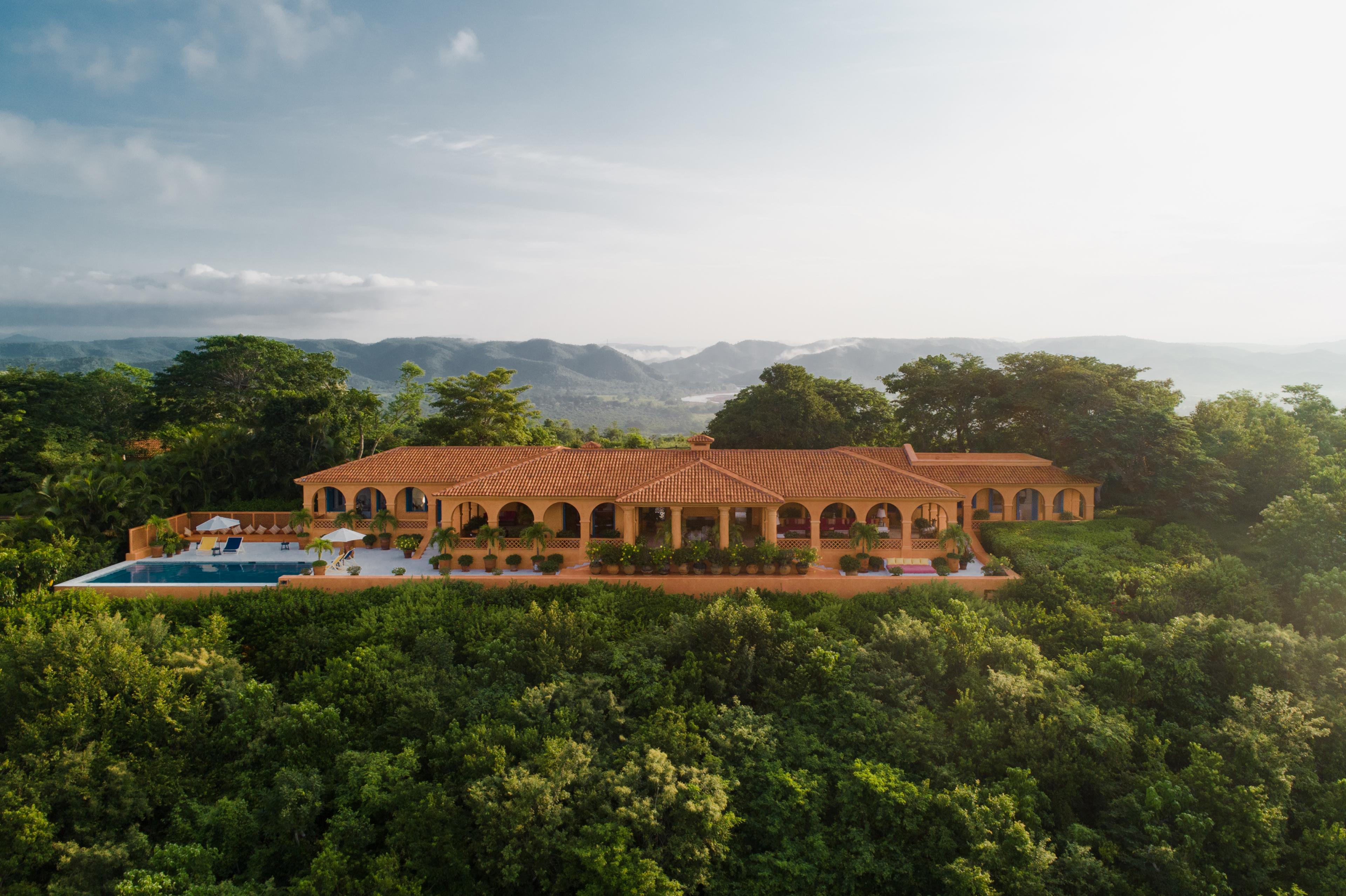 orange gold villa with arches and a pool on the deck up on a hilltop