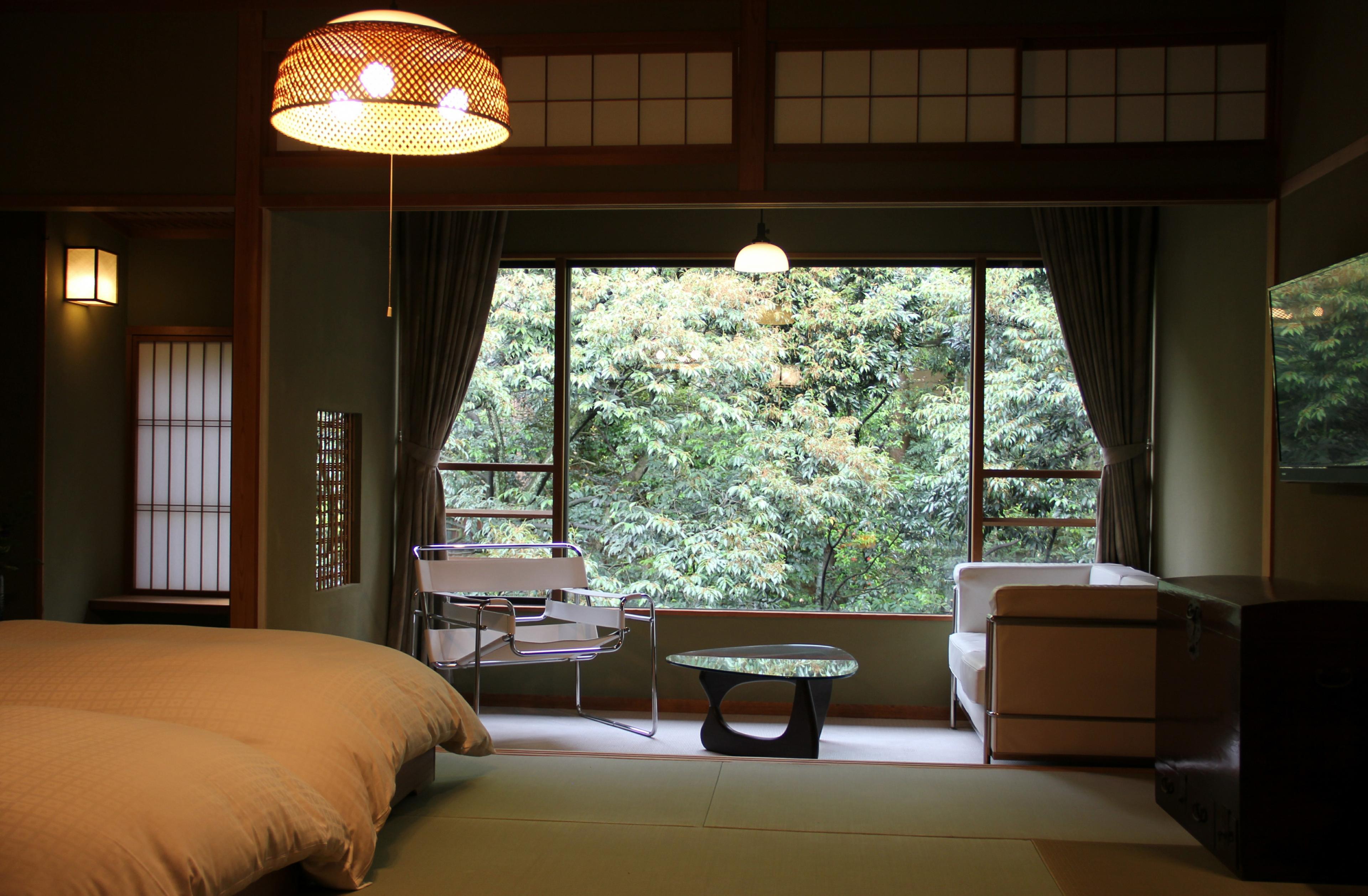 japanese style bedroom with big windows looking out on greenery