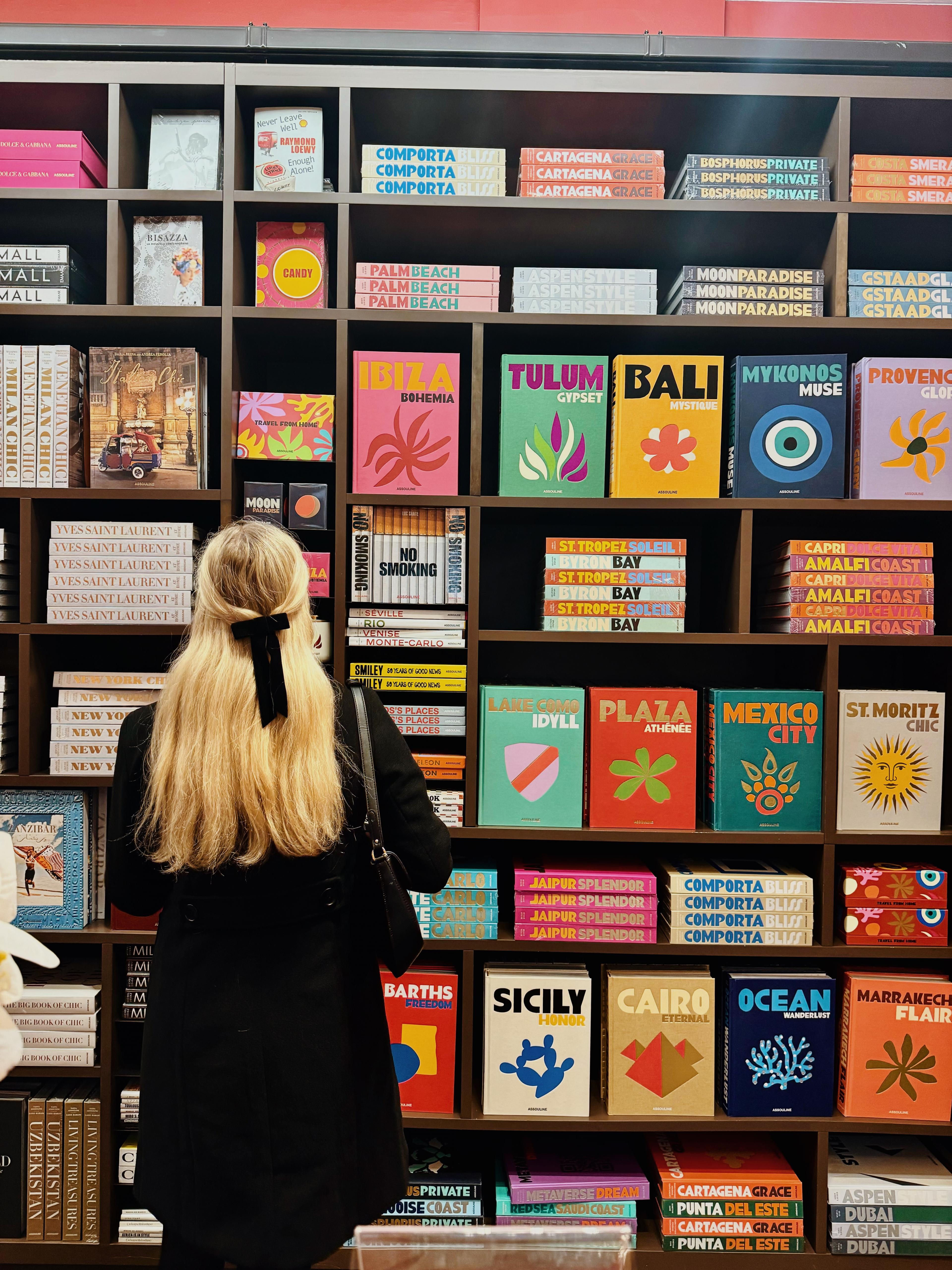 woman in bookstore looking at wall of books