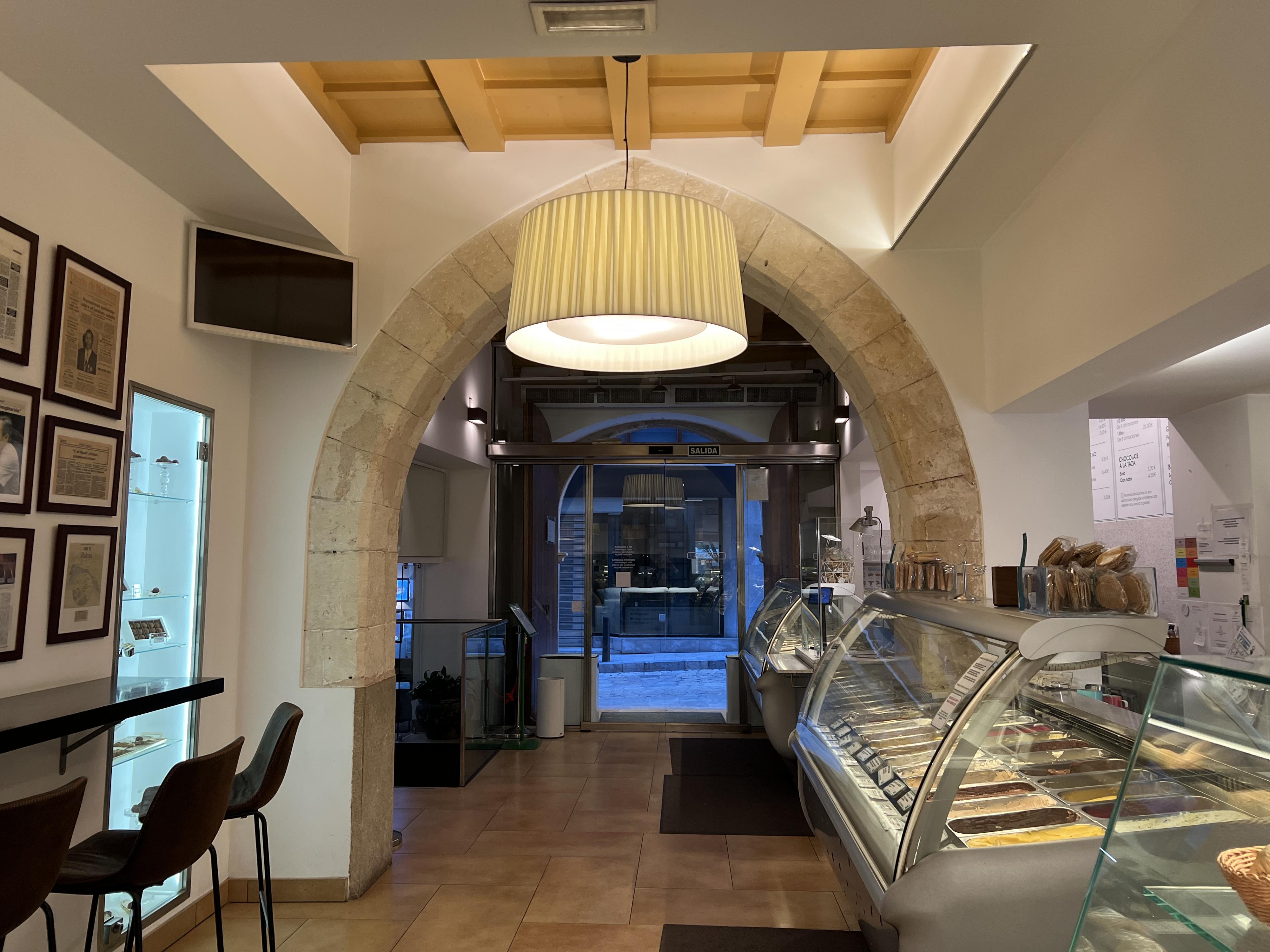 Ice cream shop with seating against the left wall and ice cream choices along the right side 