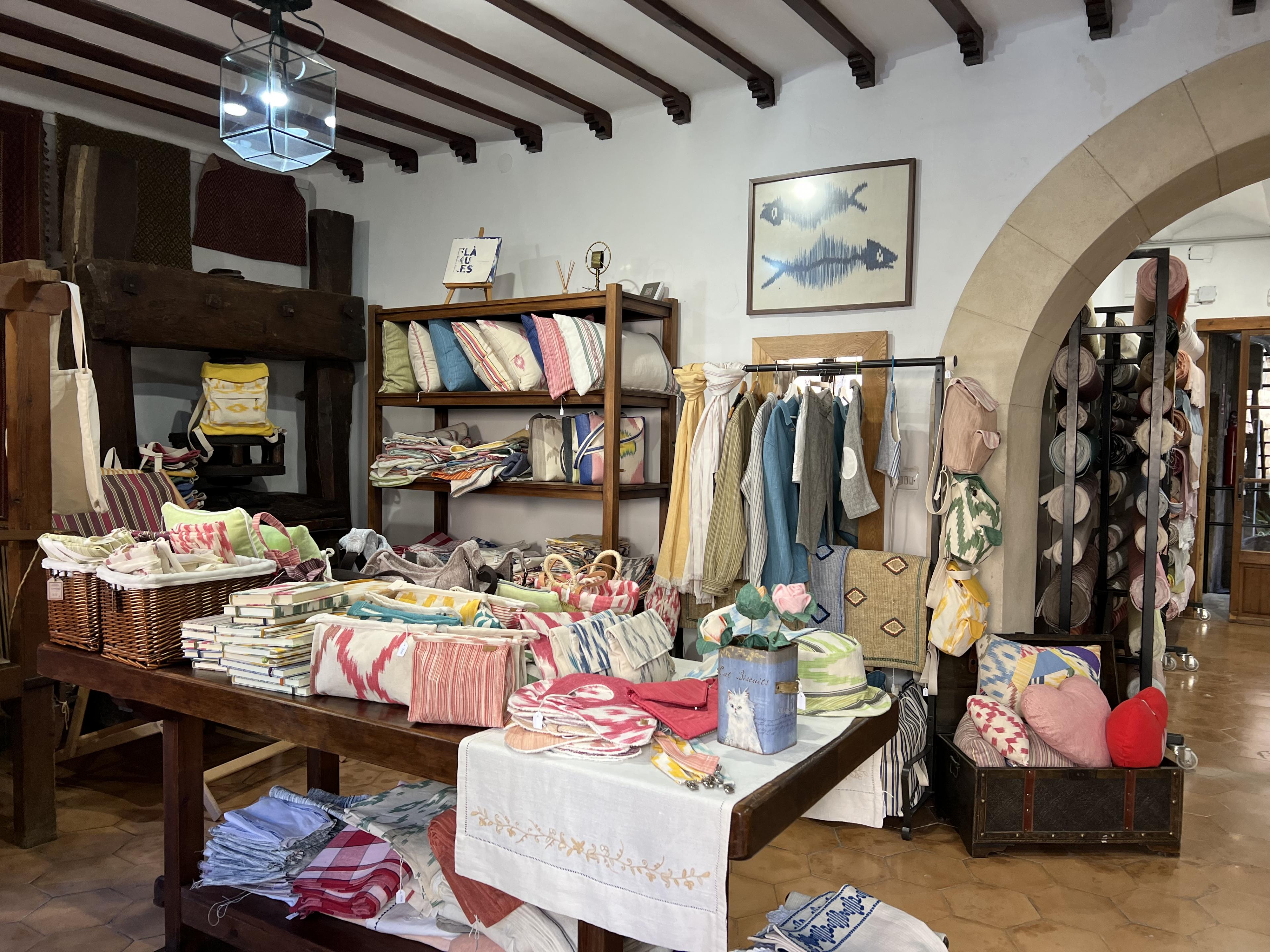 Textile shop full of pillows, scarves, blankets, and clothing 