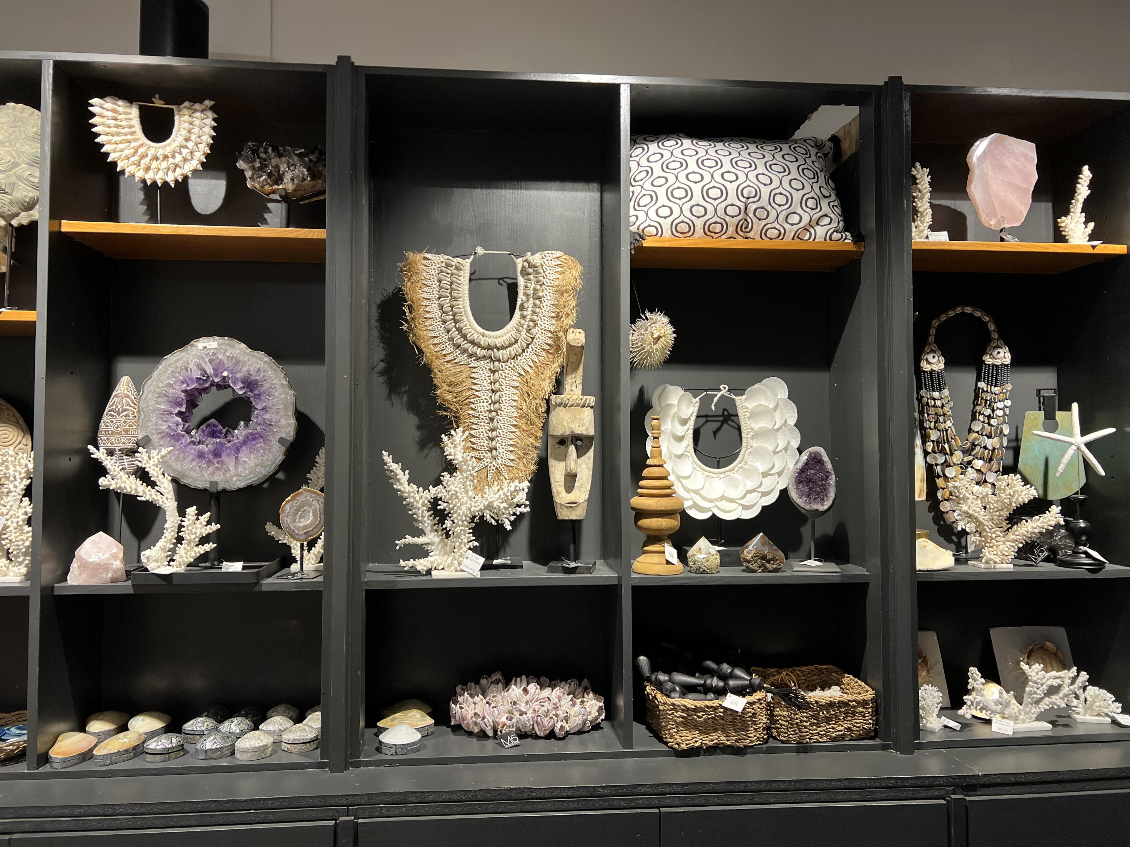 Shelves stocked with gemstones, shell necklaces and nautical decor 