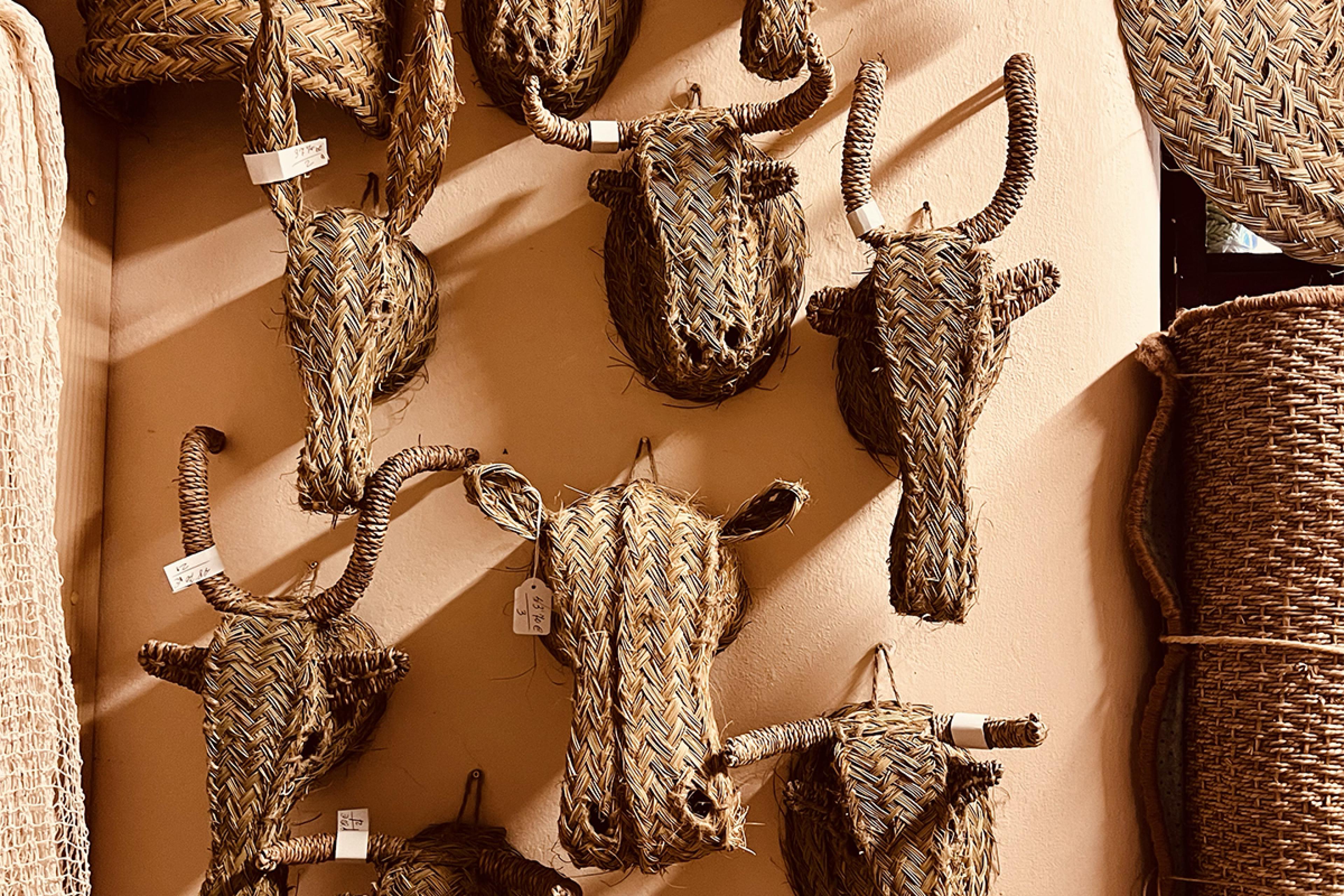 straw animal busts mimicking hunting trophies hanging on display in straw basket store
