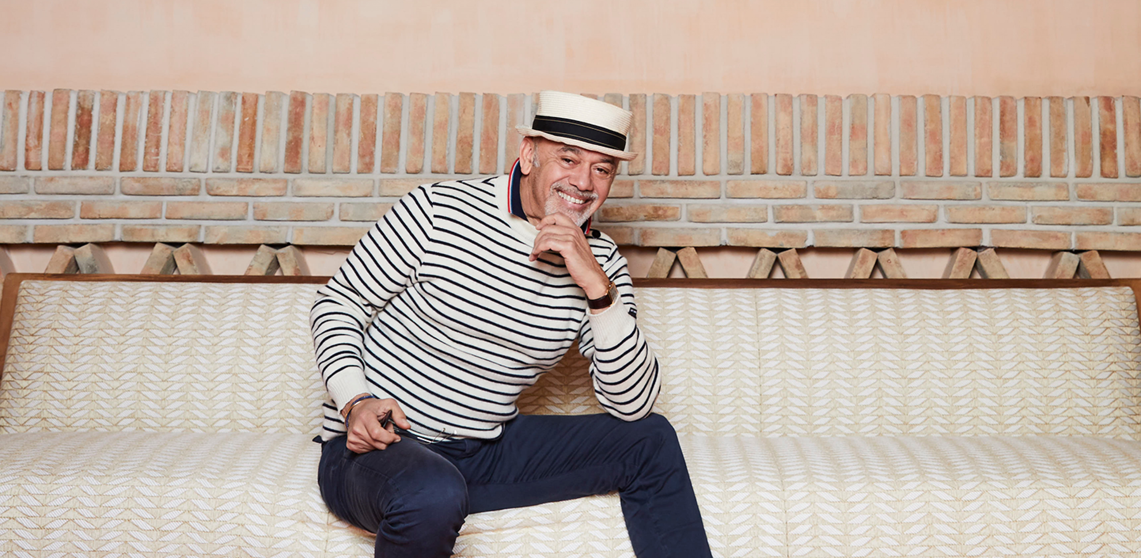 Christian Louboutin sitting on a couch