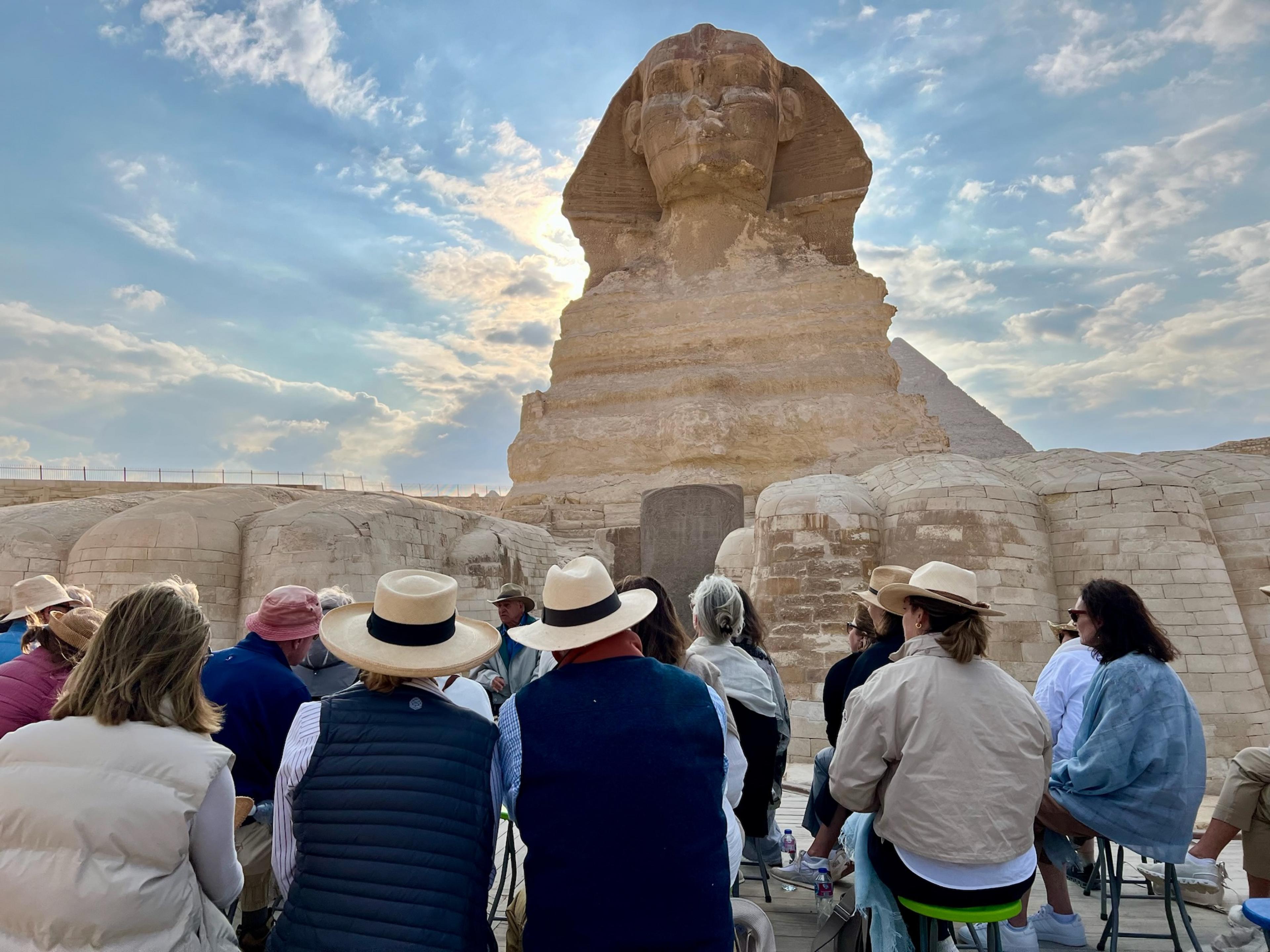 group of people with their backs to camera facing the egypt sphinx