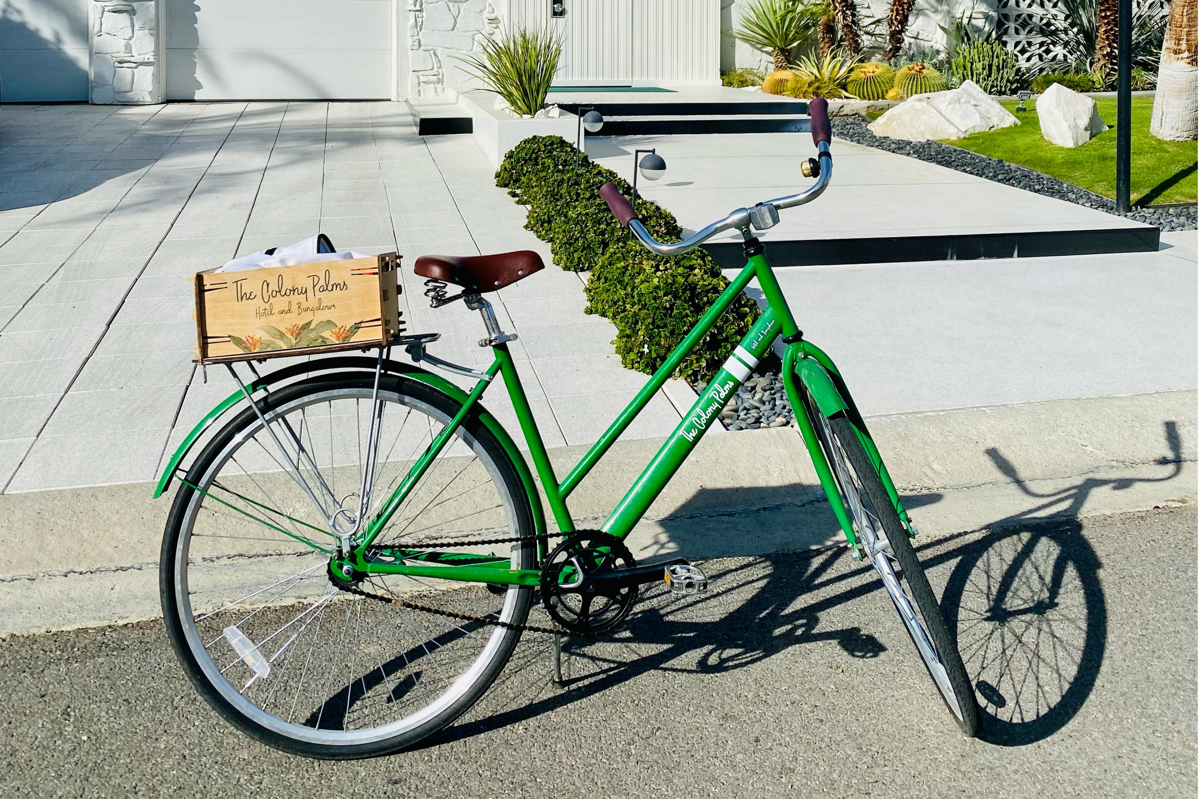 Green bike with a wooden basket on the back