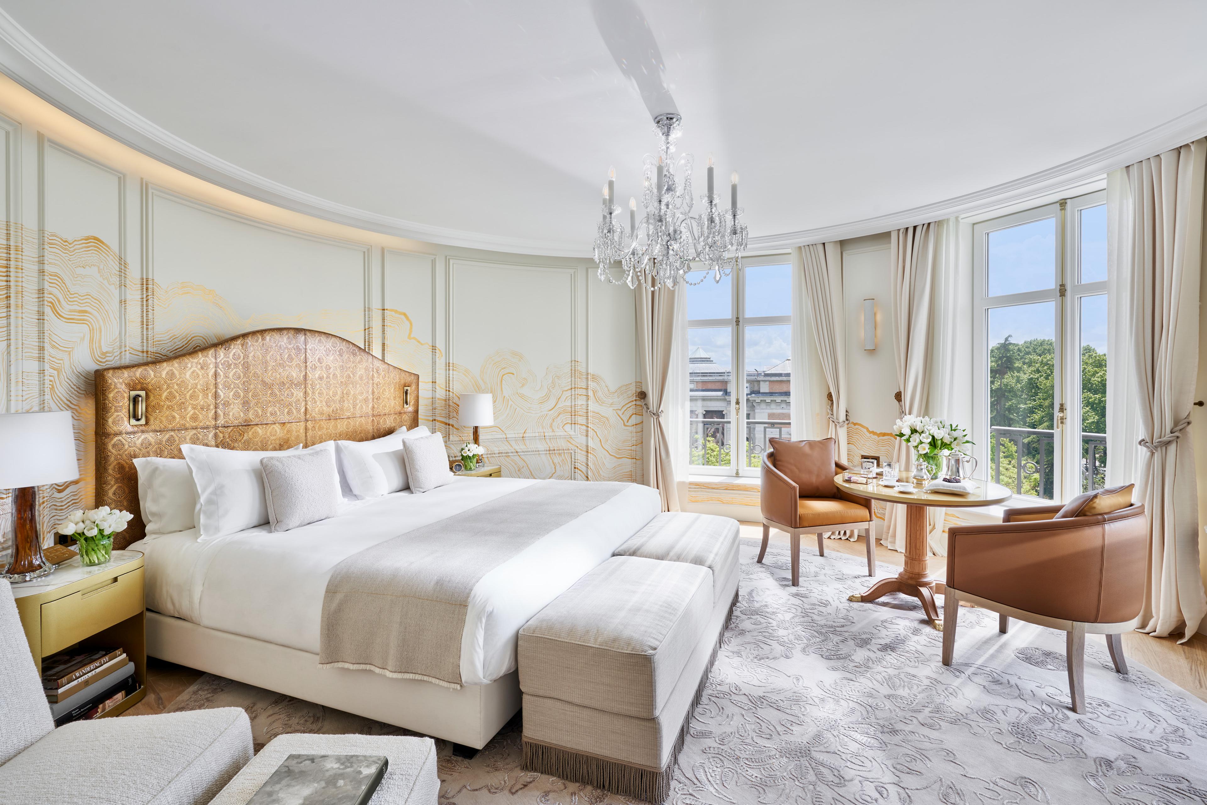 hotel room with light tones, a crystal chandelier and views of Madrid