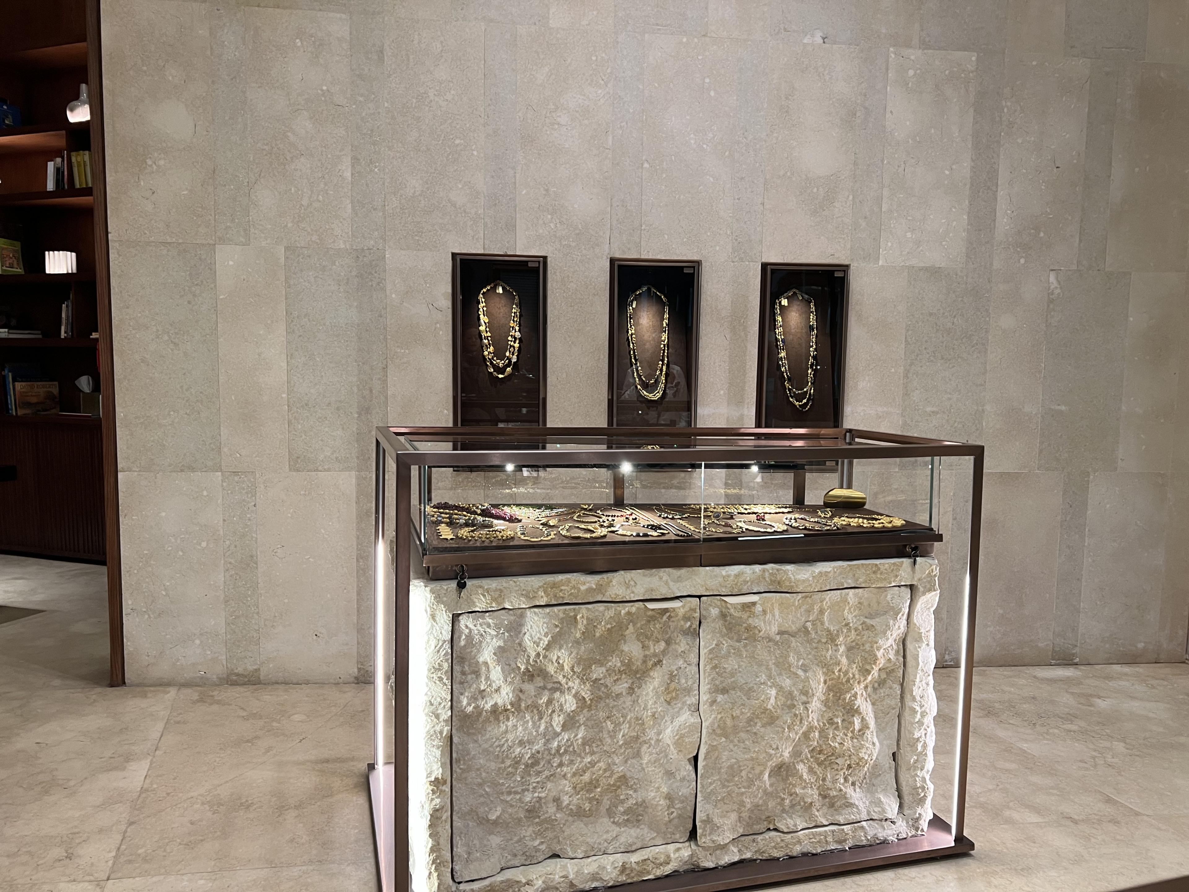 Stone and glass display case with jewelry inside of case 