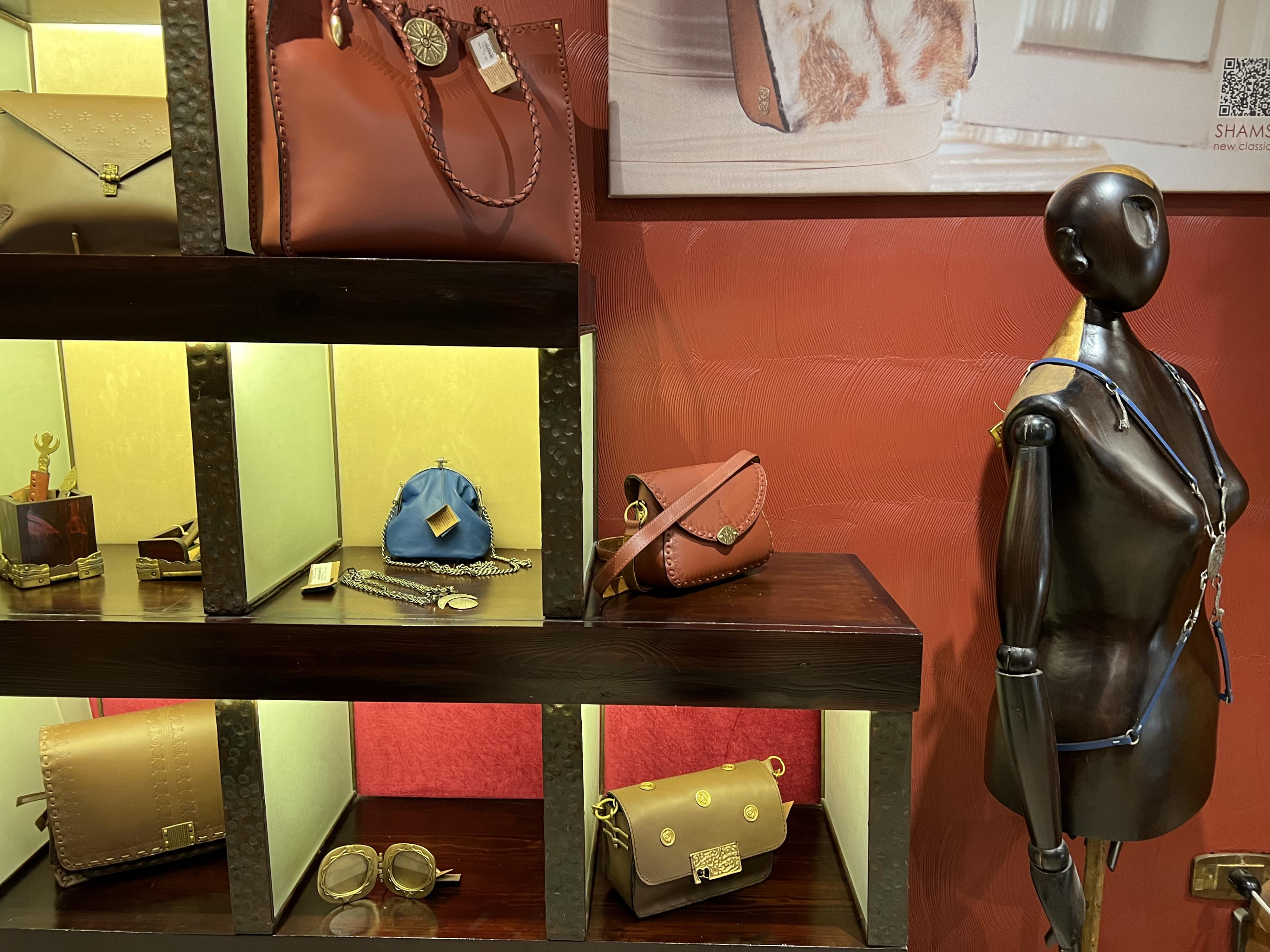Shelves with purses and jewelry in each cubby and a mannequin displaying jewelry 