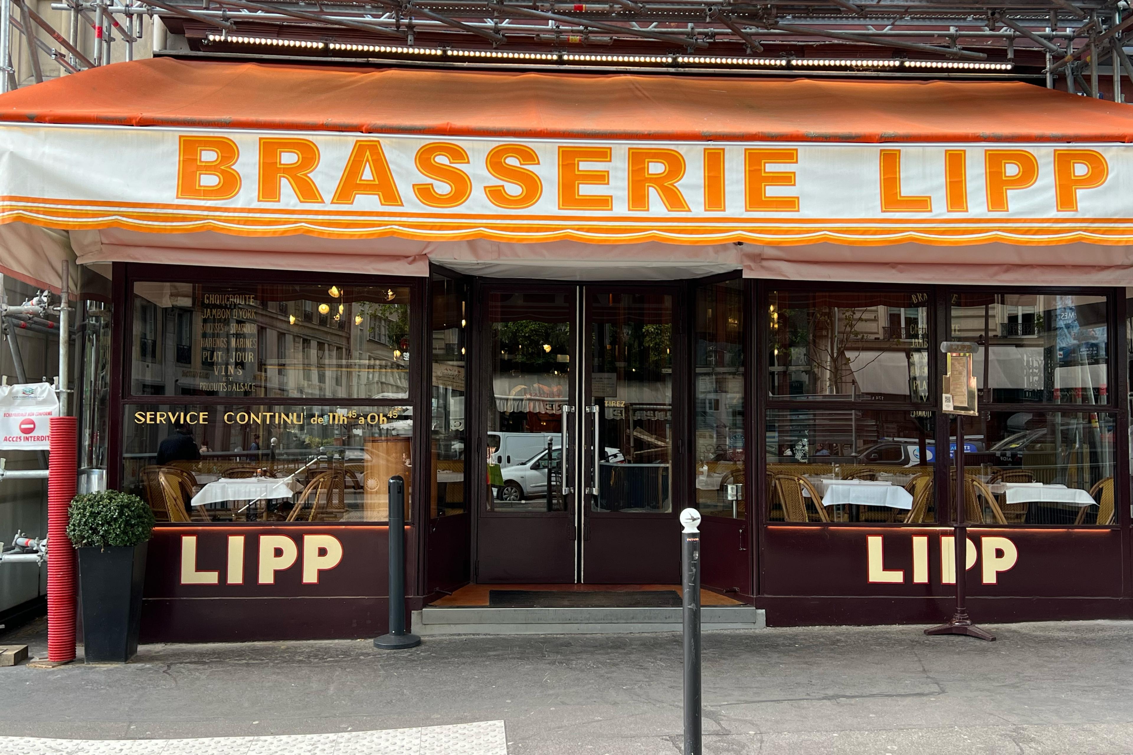 brasserie with a orange and white sign and glass windows