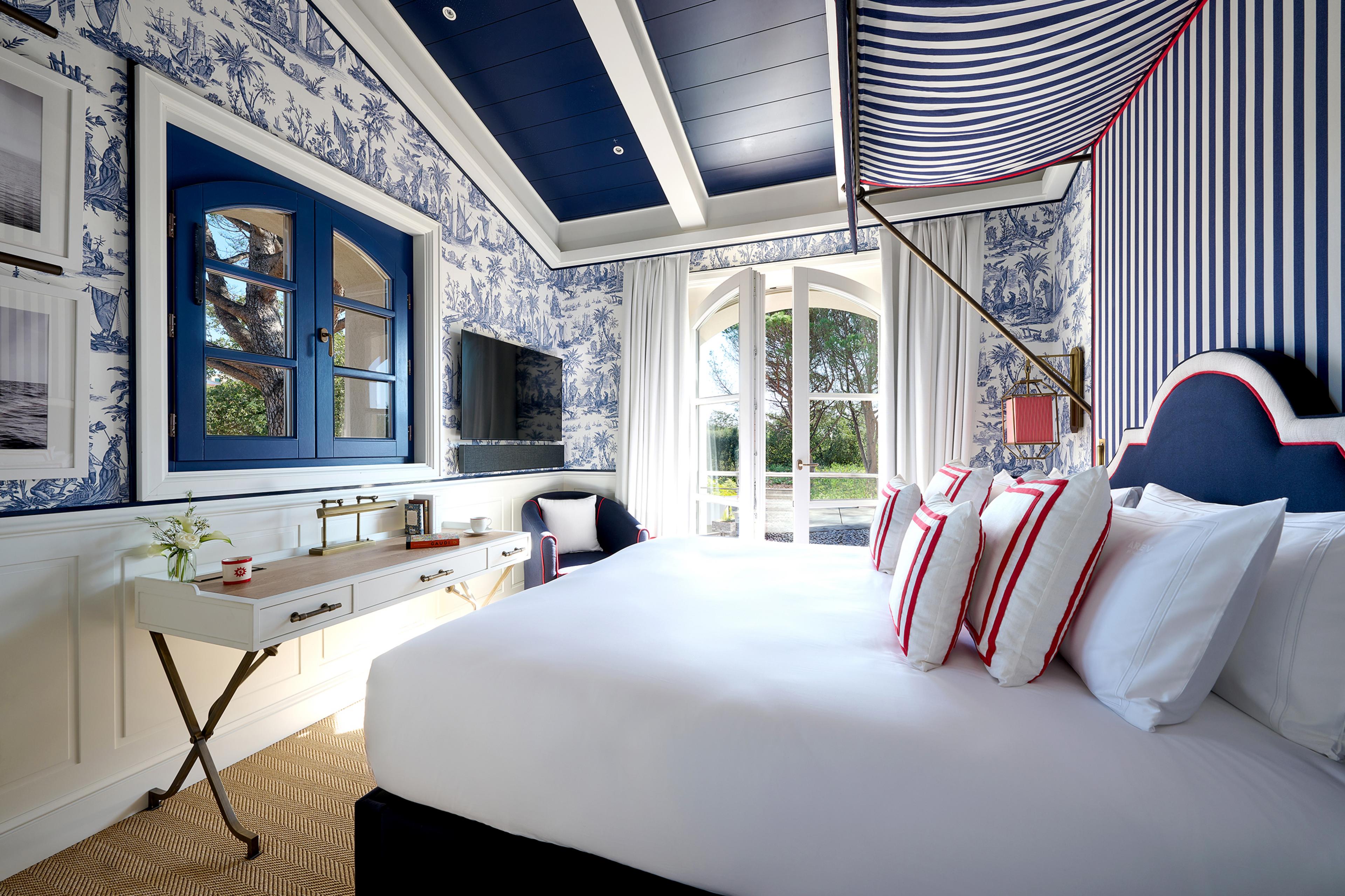 hotel room with blue and white striped walls and ceiling and red accents in decoration 