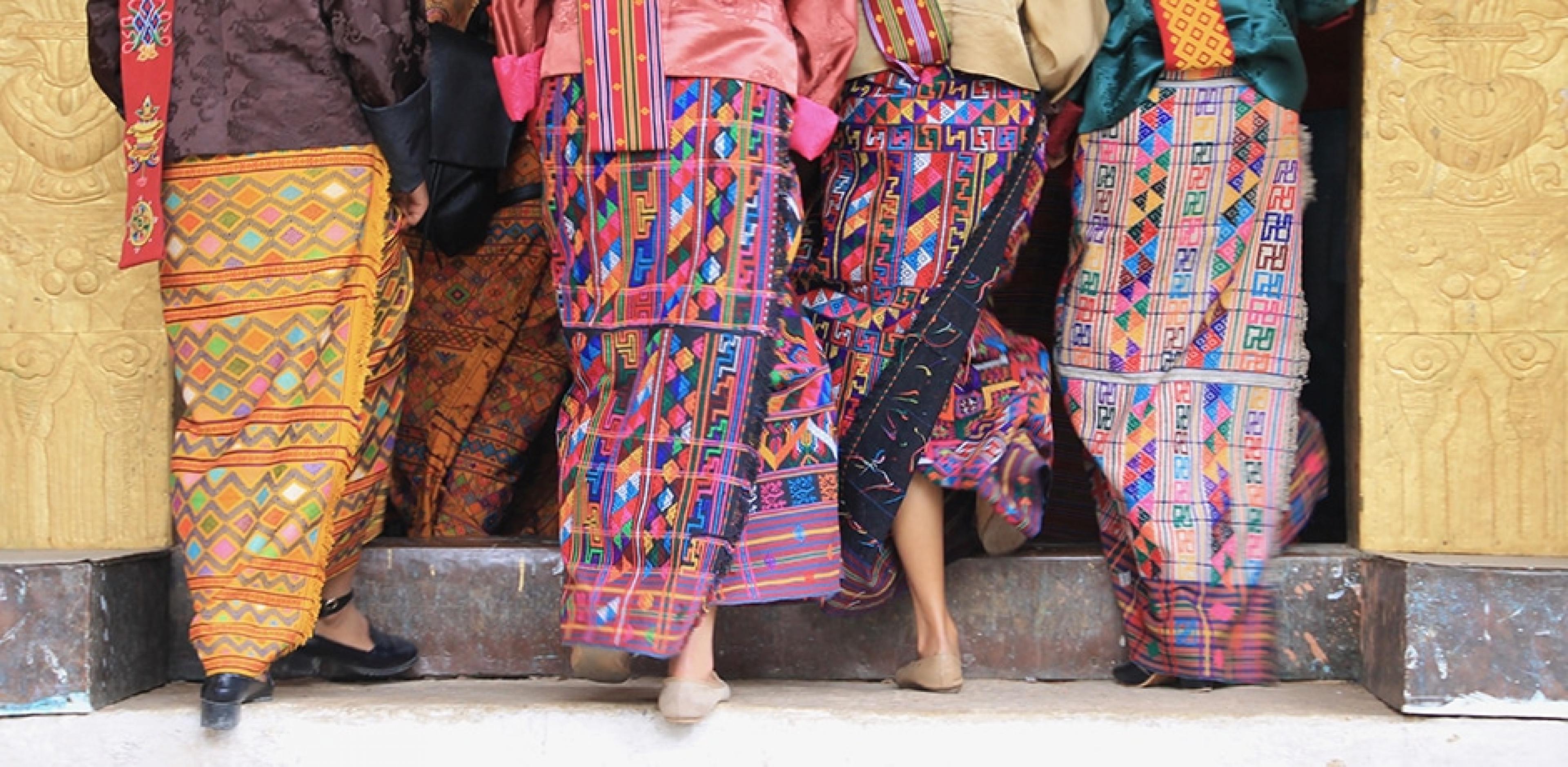 women in bhutan wearing colorful skirts