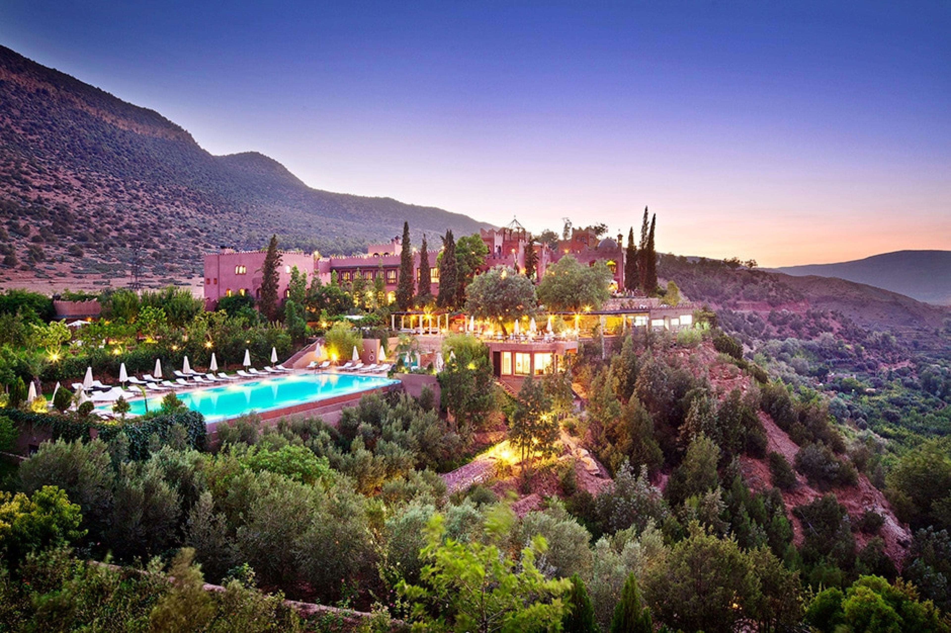 grand hotel in morocco atlas mountains with pool on a hill at dusk