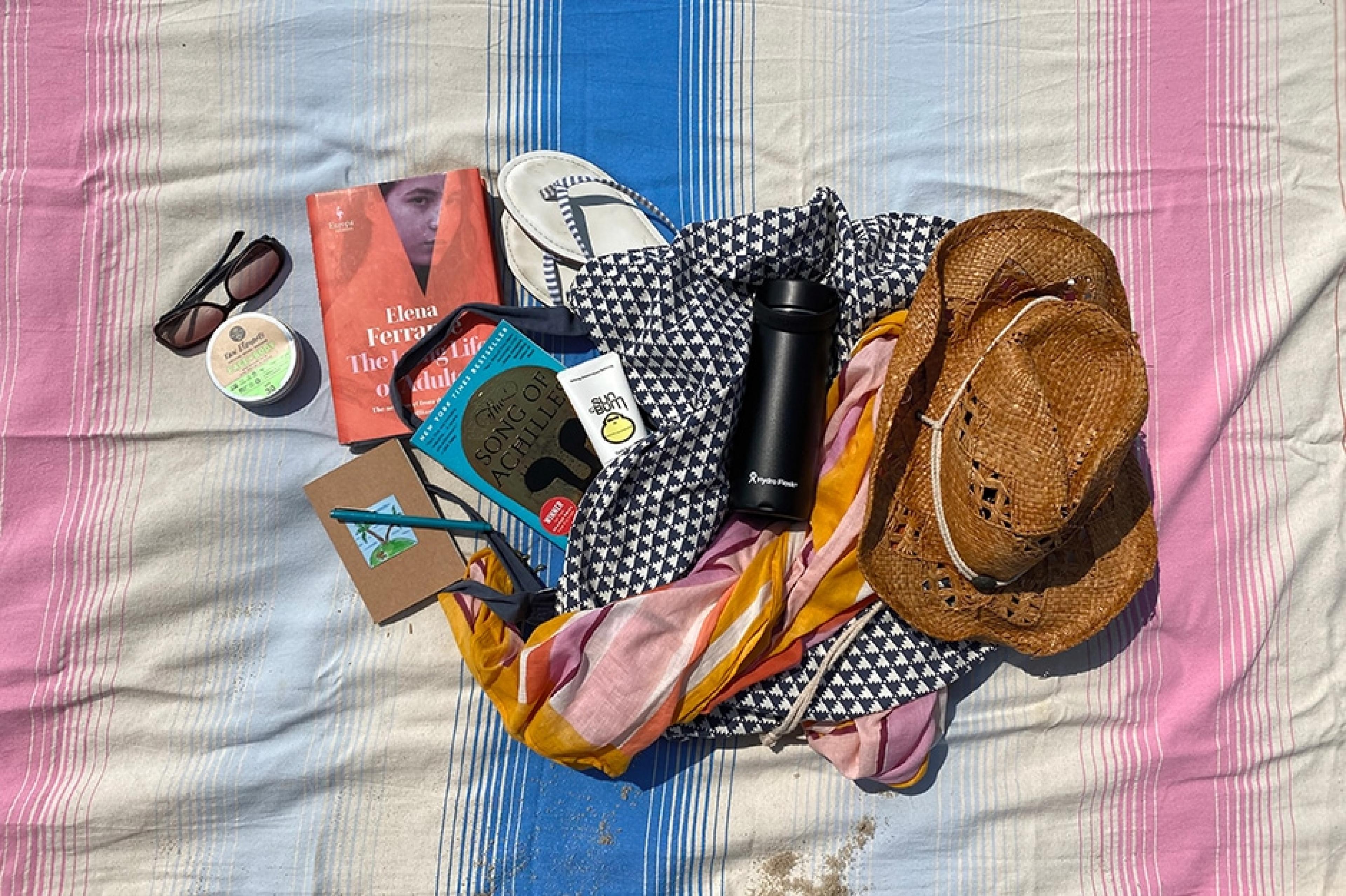contents of a beach bag emptied on a beach towel