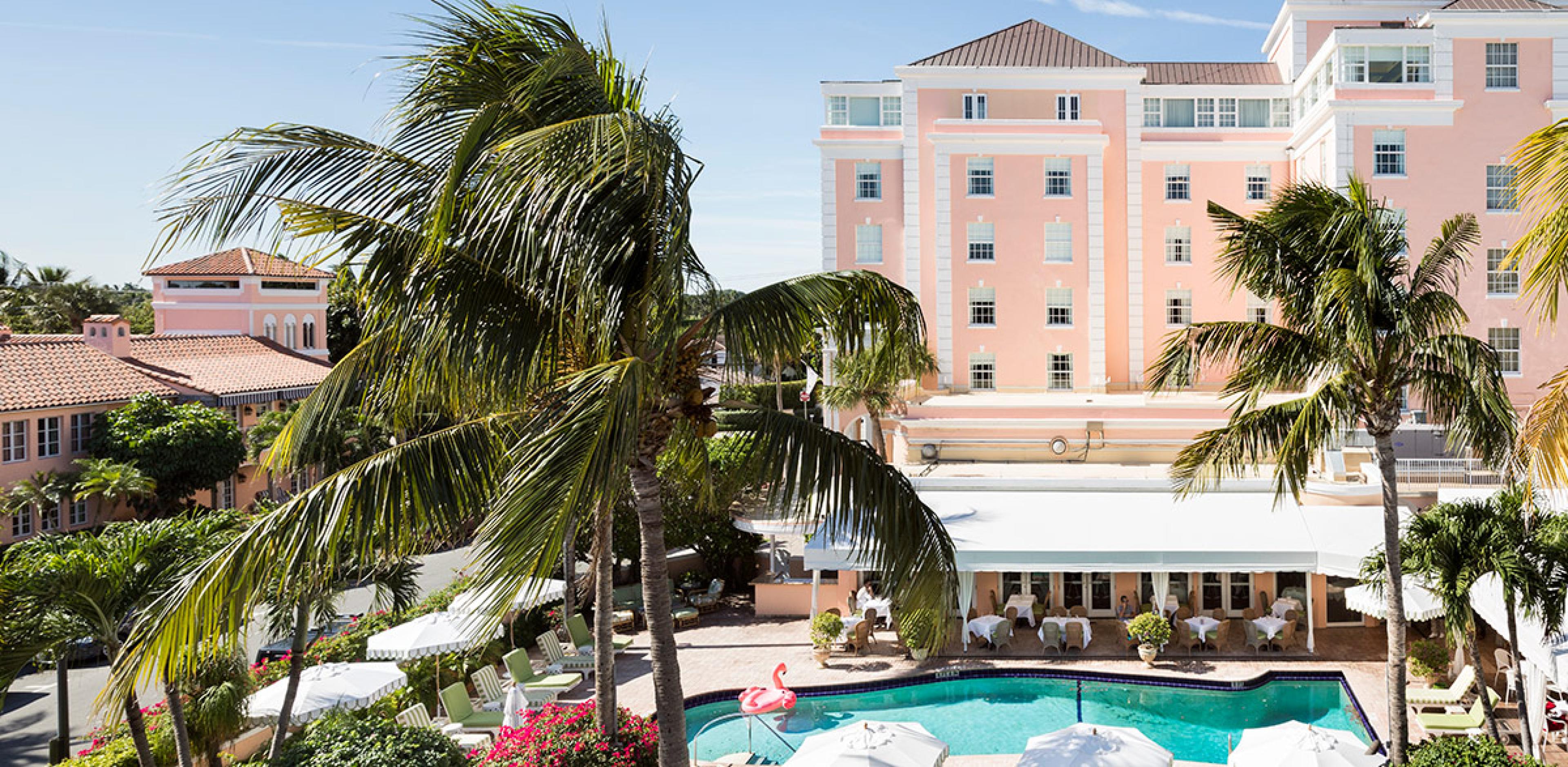 view over hotel pool with pink hotel building in background