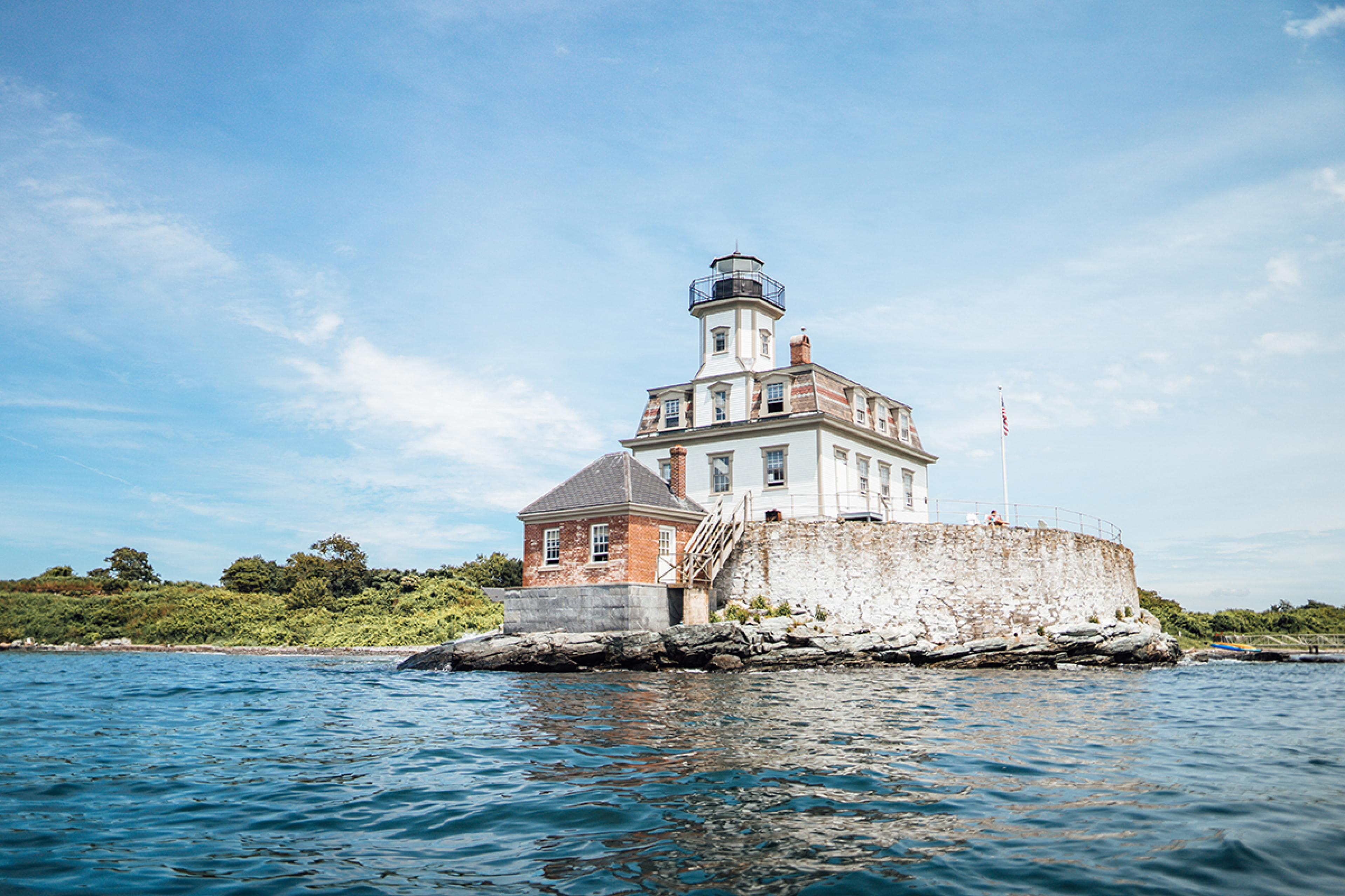 Lighthouse on rocks in a harbor in Newport