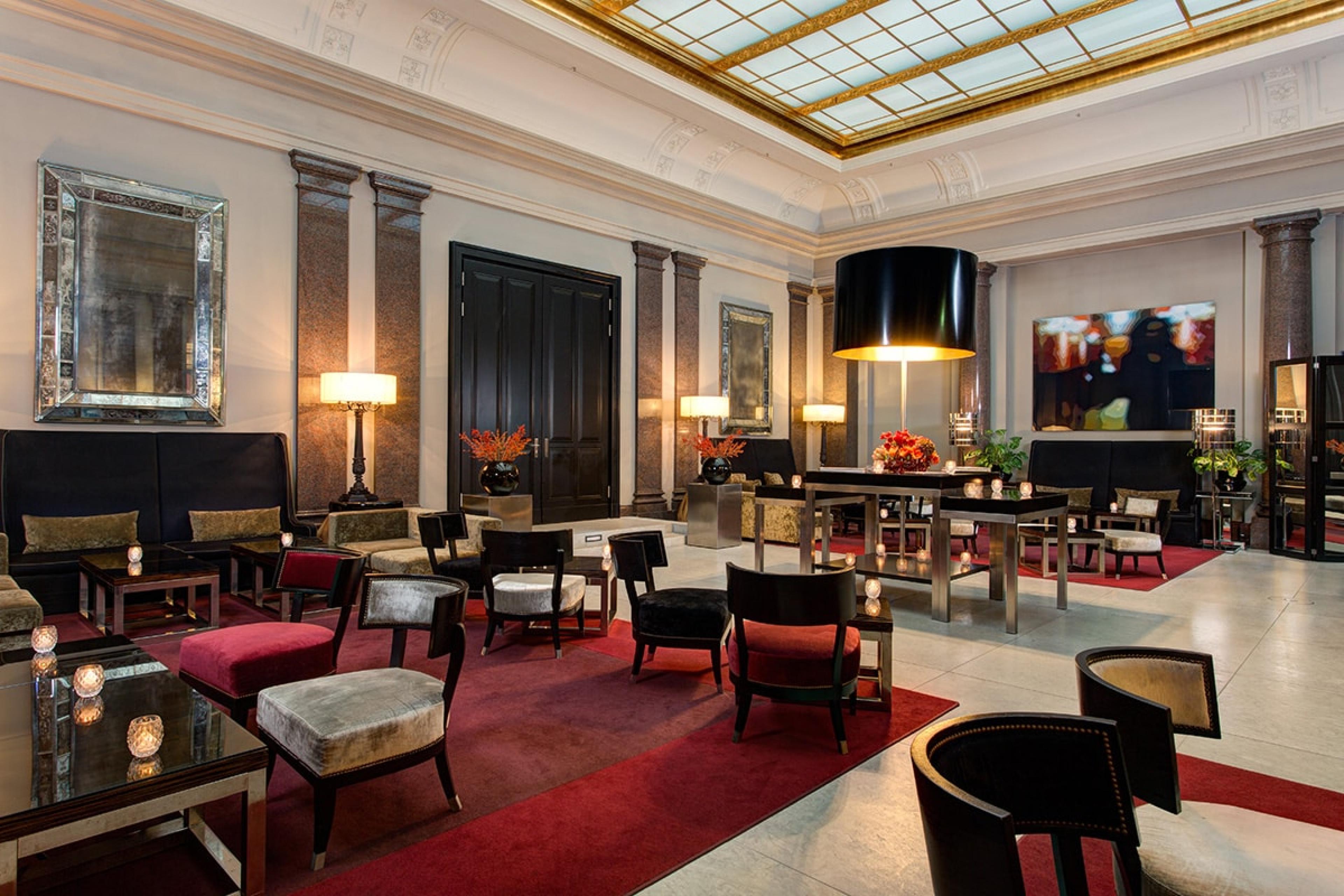 inside hotel lounge with glass skylight ceiling and red carpeting