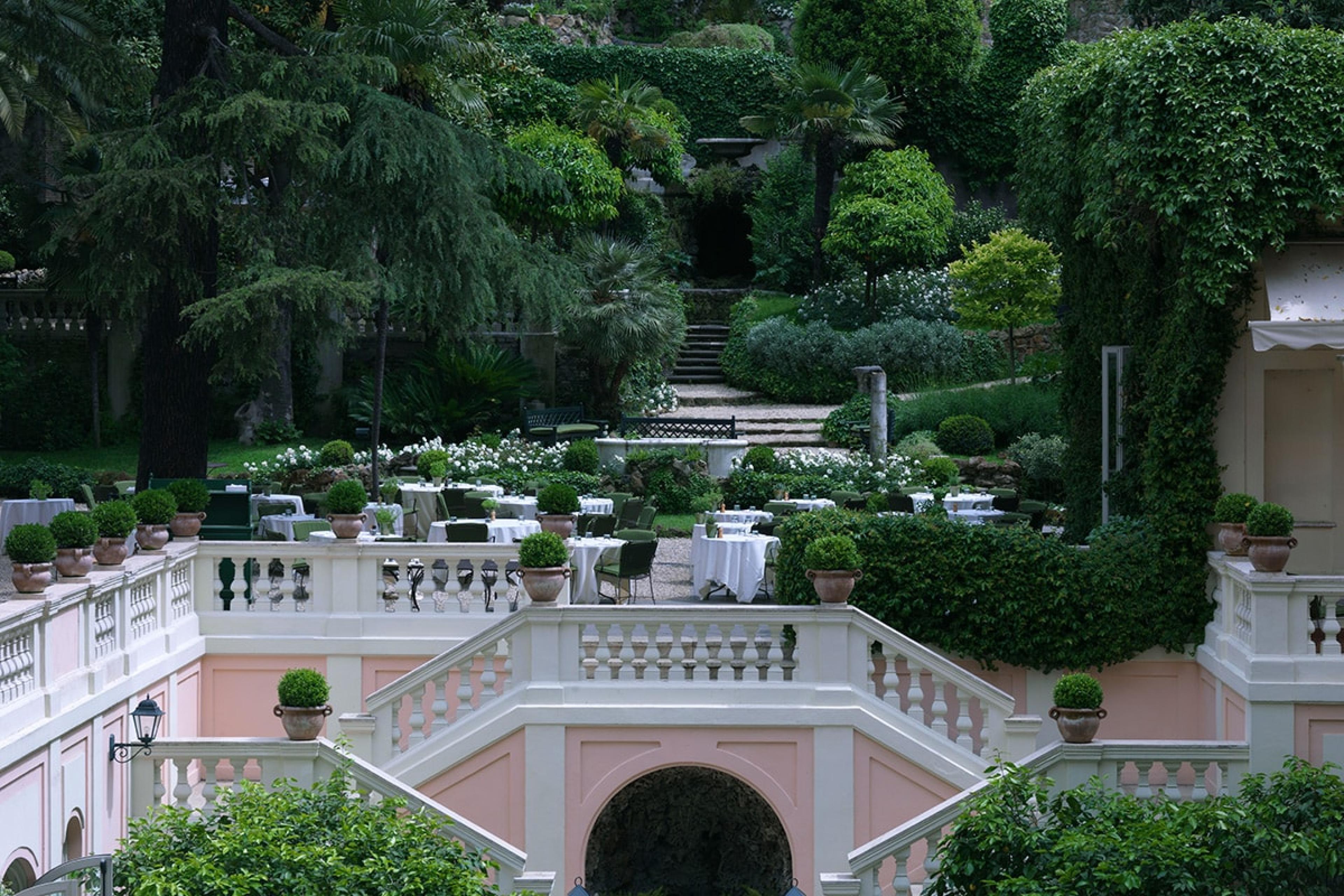 gardens in rome with pink and white grand staircase in center at a hotel