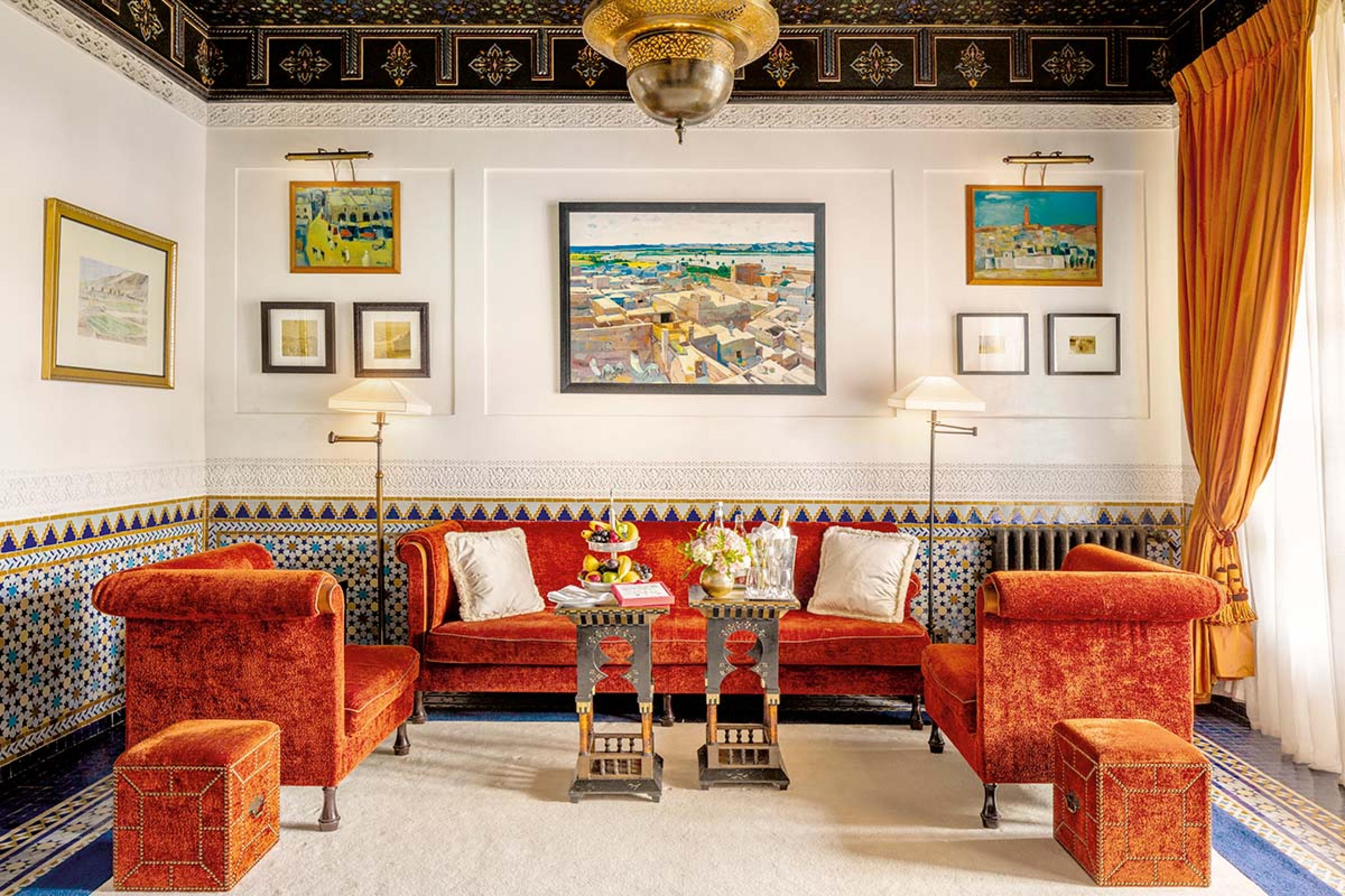 living room with orange crushed velvet couches and paintings on the walls