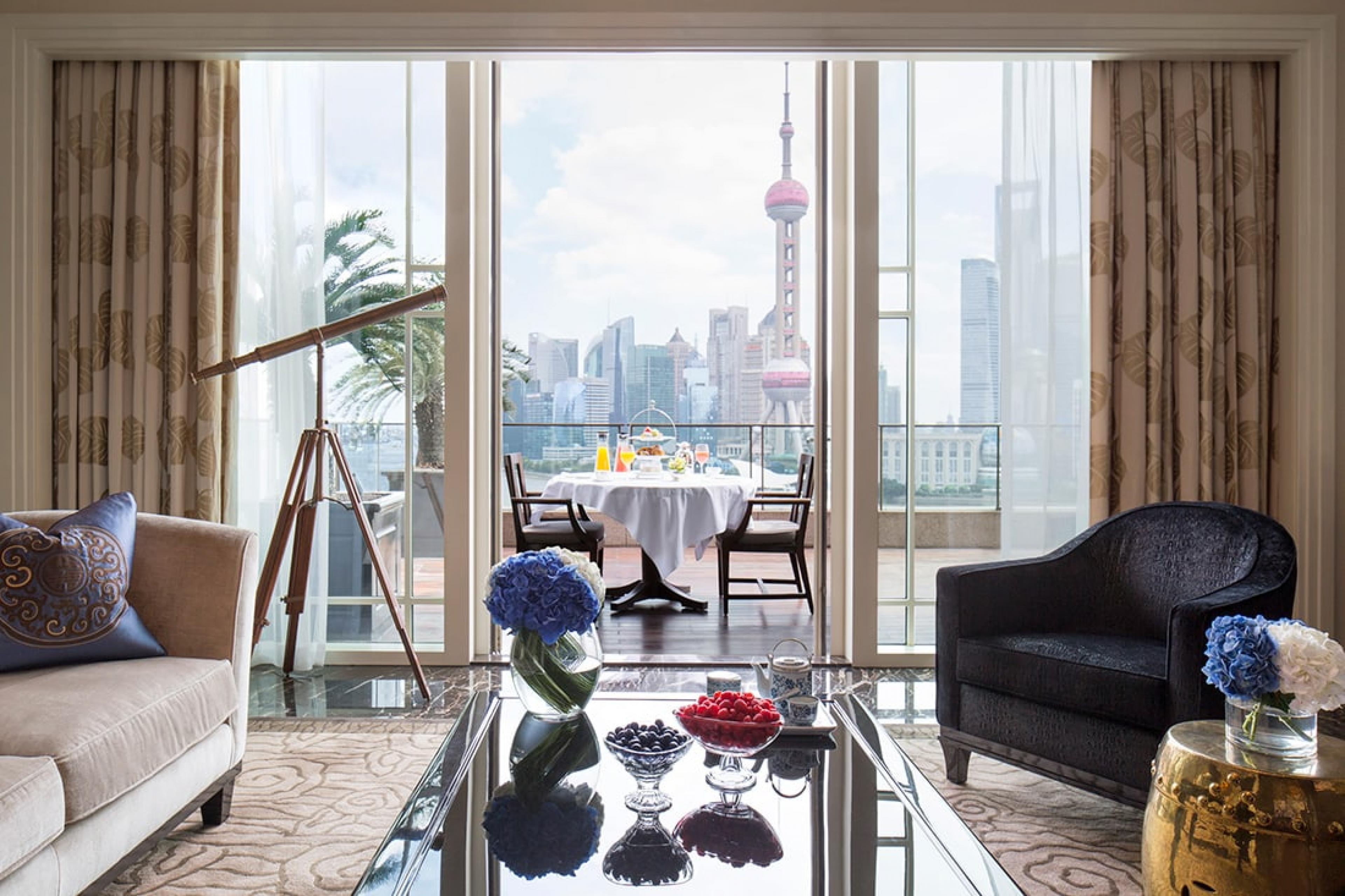 living room of a hotel suite with view over Shanghai skyline